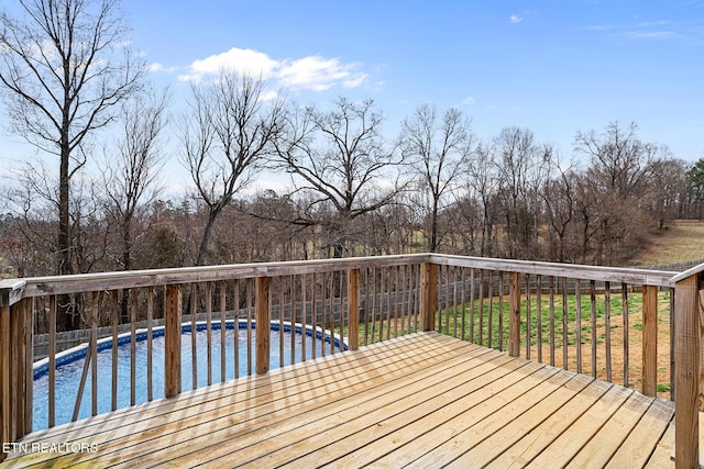 wooden terrace with a fenced in pool