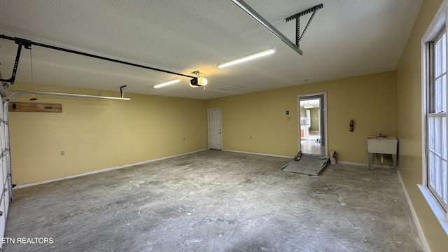 garage featuring a garage door opener and baseboards