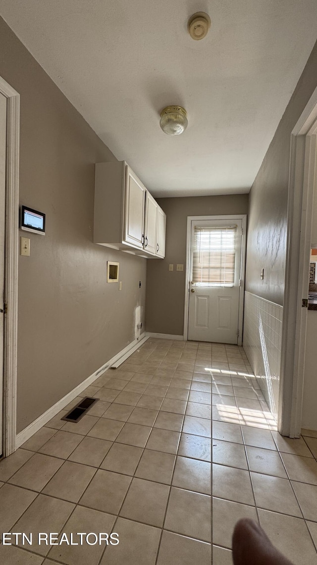 washroom with light tile patterned floors, visible vents, baseboards, cabinet space, and washer hookup