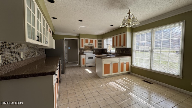 kitchen with visible vents, under cabinet range hood, a sink, dark countertops, and white electric range oven