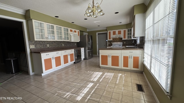 kitchen featuring visible vents, a notable chandelier, stainless steel refrigerator with ice dispenser, a sink, and dark countertops