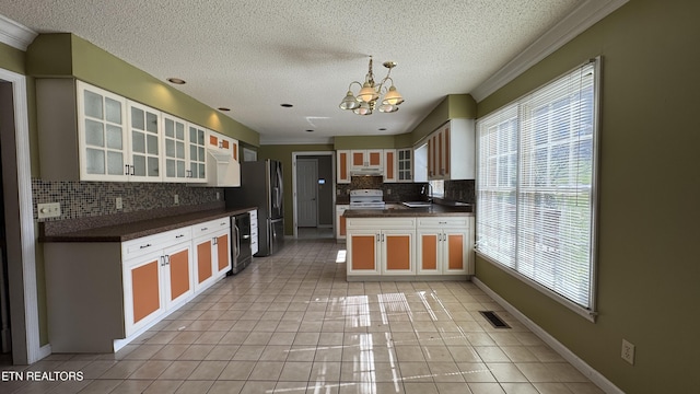 kitchen featuring visible vents, light tile patterned flooring, a sink, dark countertops, and a chandelier