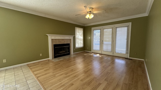 unfurnished living room with light wood-type flooring, a fireplace, a ceiling fan, and crown molding