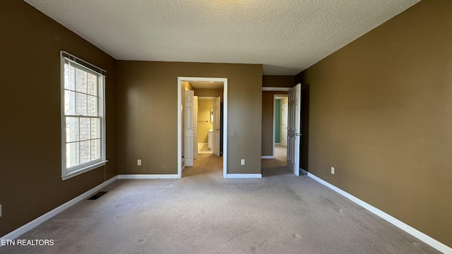 unfurnished bedroom with baseboards, visible vents, multiple windows, and carpet floors