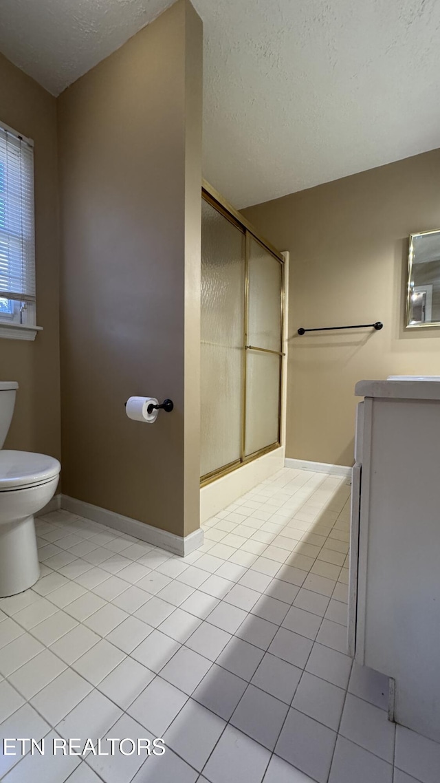 bathroom with vanity, tile patterned flooring, a shower stall, a textured ceiling, and toilet