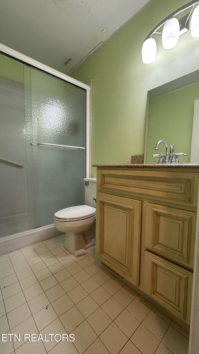 full bathroom featuring vanity, tile patterned floors, toilet, and a stall shower