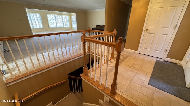 stairway with tile patterned floors, crown molding, and baseboards