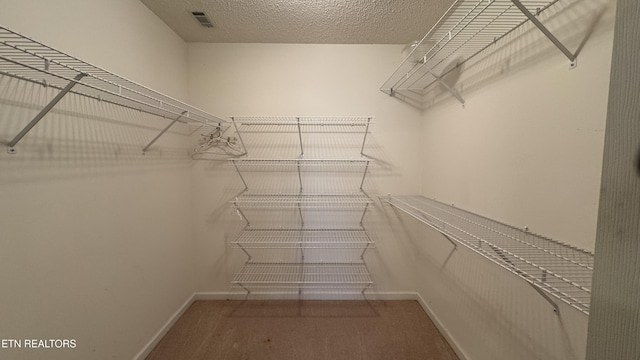 walk in closet featuring visible vents and carpet floors