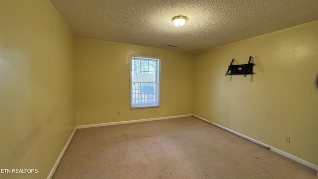 empty room featuring baseboards, carpet floors, and a textured ceiling