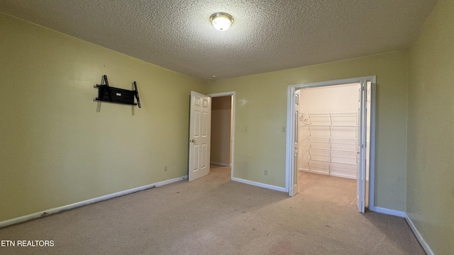 unfurnished bedroom with carpet, baseboards, and a textured ceiling