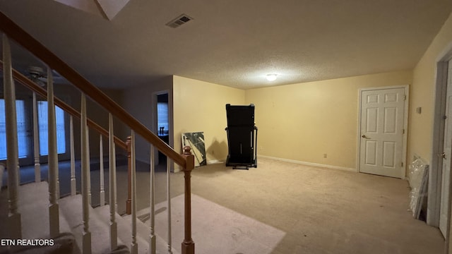 interior space with visible vents, a textured ceiling, carpet, and baseboards