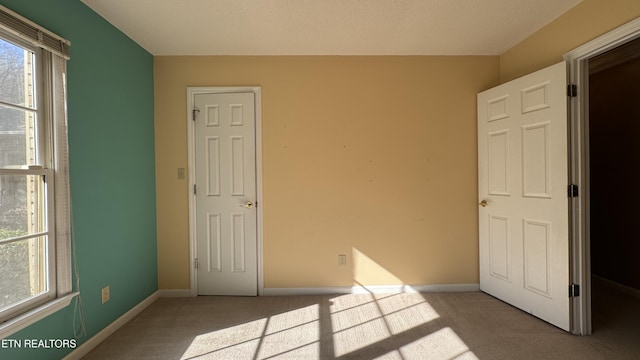 unfurnished bedroom featuring carpet flooring and baseboards