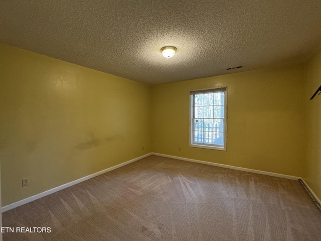 carpeted empty room with a textured ceiling, baseboards, and visible vents