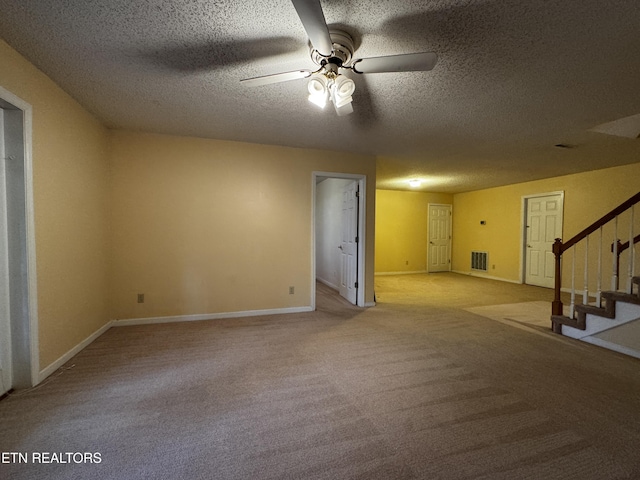 empty room with a ceiling fan, a textured ceiling, stairs, and visible vents