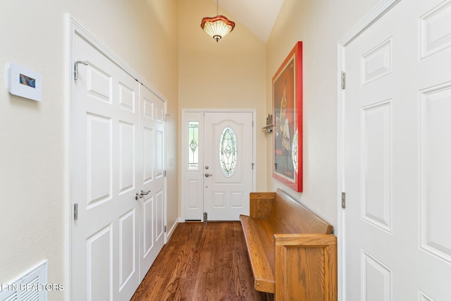 entryway with dark wood finished floors and vaulted ceiling