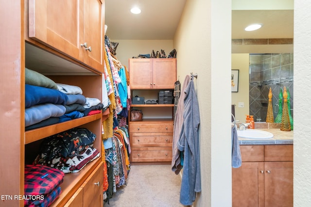 walk in closet featuring light colored carpet and a sink