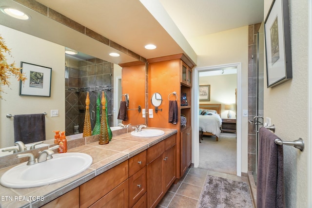 ensuite bathroom featuring double vanity, a stall shower, ensuite bathroom, and a sink