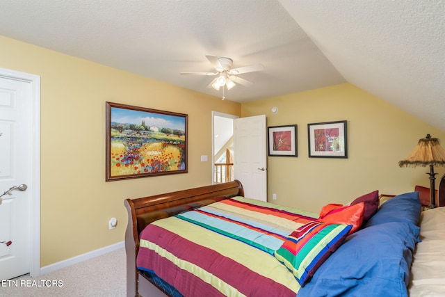 carpeted bedroom with a textured ceiling, lofted ceiling, baseboards, and a ceiling fan