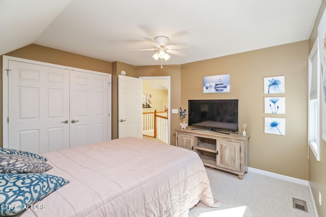 carpeted bedroom with visible vents, a closet, baseboards, ceiling fan, and vaulted ceiling