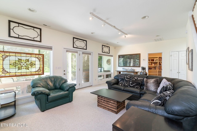 living area with rail lighting, carpet flooring, and visible vents