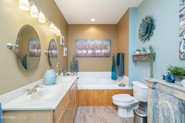 bathroom with double vanity, toilet, a bath, and a sink