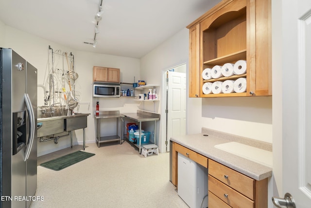 kitchen featuring track lighting, open shelves, built in desk, appliances with stainless steel finishes, and light countertops