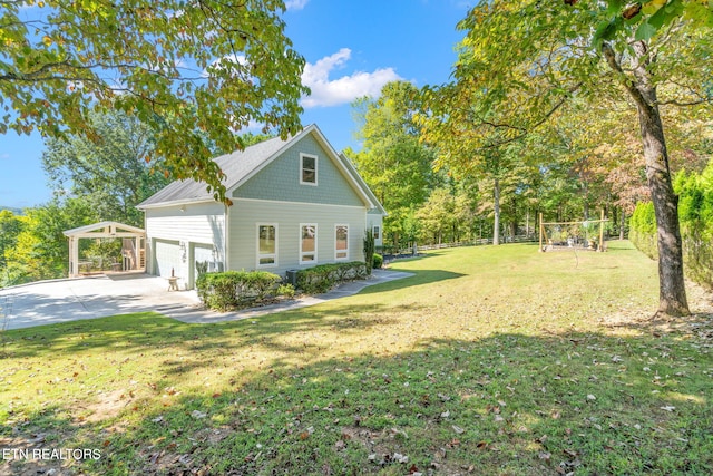 view of front of property featuring a front yard, concrete driveway, fence, and a garage