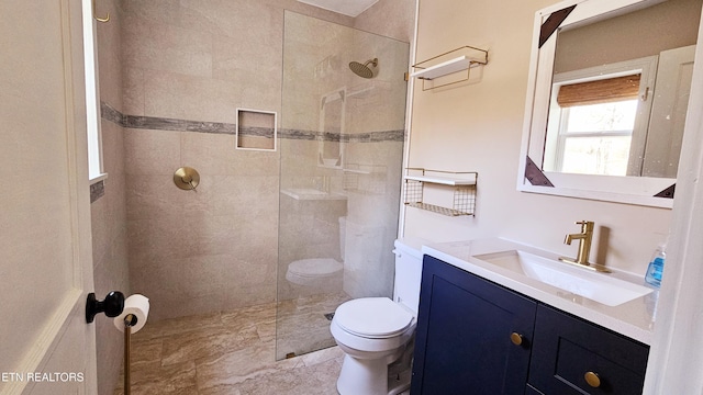 bathroom featuring a walk in shower, toilet, and vanity