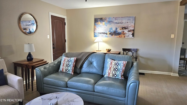 living area featuring visible vents, baseboards, and wood-type flooring