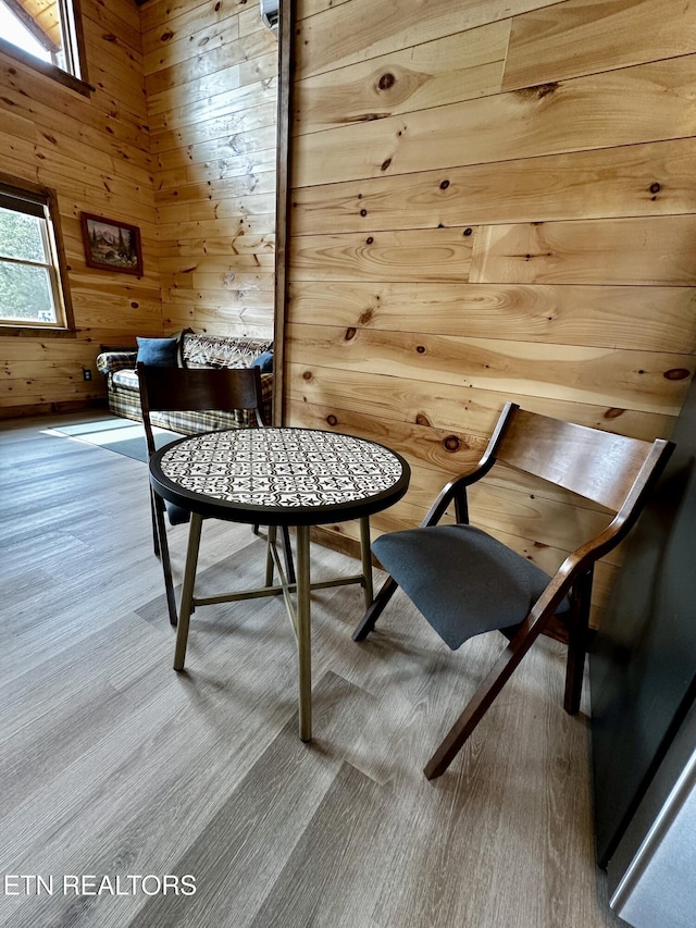 dining area featuring wood finished floors and wood walls