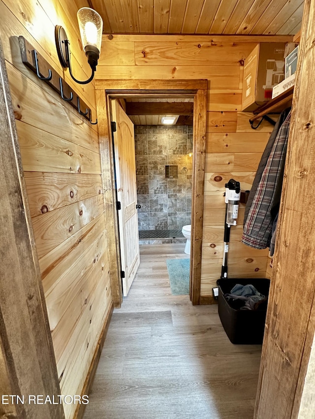 interior space with wood finished floors, wood ceiling, and wood walls