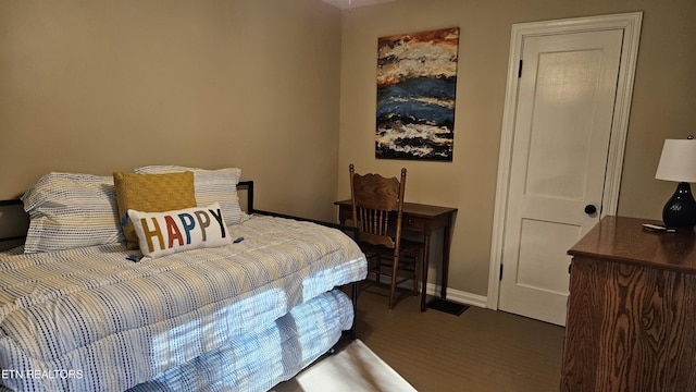 bedroom with baseboards and wood finished floors