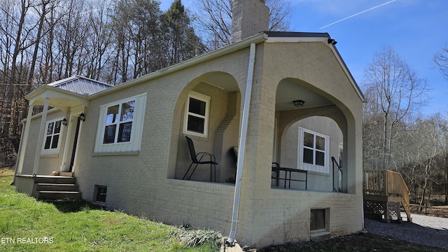 view of side of property featuring brick siding and a chimney