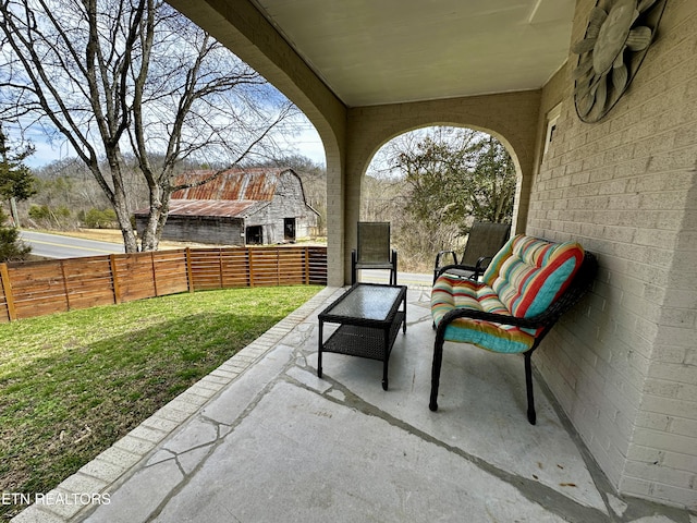 view of patio featuring outdoor lounge area and fence