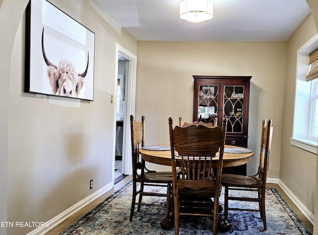 dining area featuring baseboards and wood finished floors