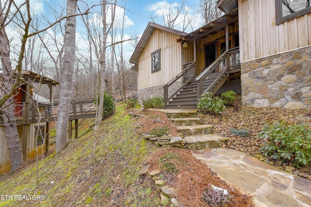 exterior space featuring stone siding and stairs