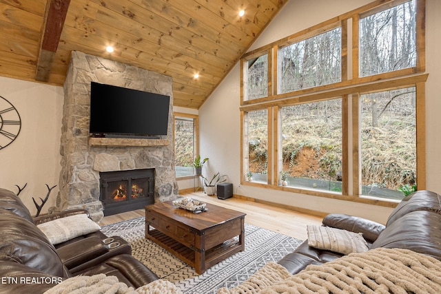 living area featuring high vaulted ceiling, a fireplace, wood ceiling, and wood finished floors