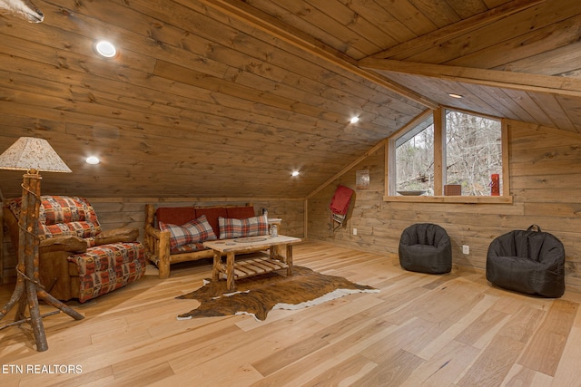 sitting room with wooden walls, wood ceiling, lofted ceiling, and wood finished floors