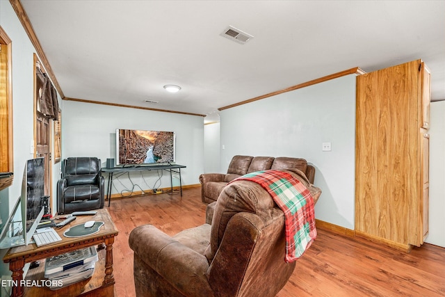 living area featuring crown molding, wood finished floors, visible vents, and baseboards