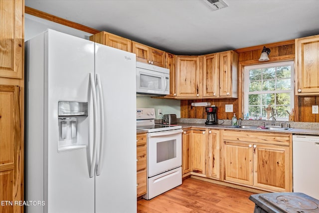 kitchen featuring visible vents, light countertops, light wood-style flooring, white appliances, and a sink