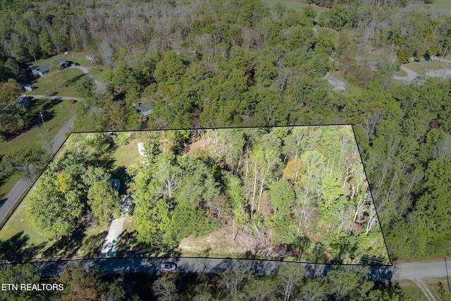 drone / aerial view featuring a wooded view