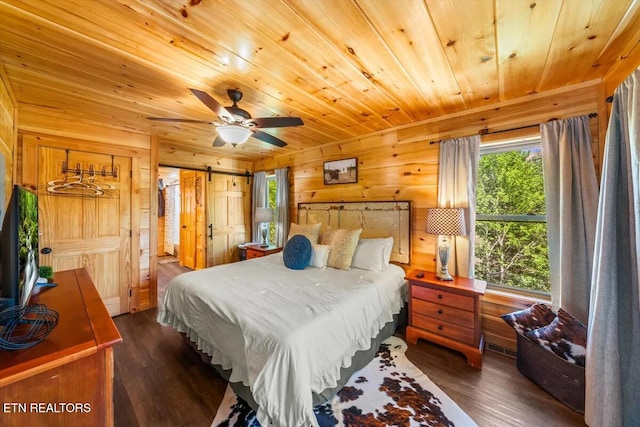 bedroom featuring a barn door, wooden walls, wood ceiling, and dark wood-type flooring