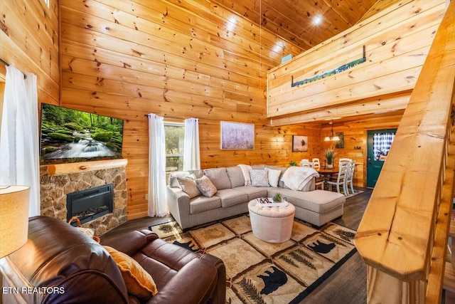 living room featuring high vaulted ceiling, wood finished floors, wooden walls, wooden ceiling, and a fireplace