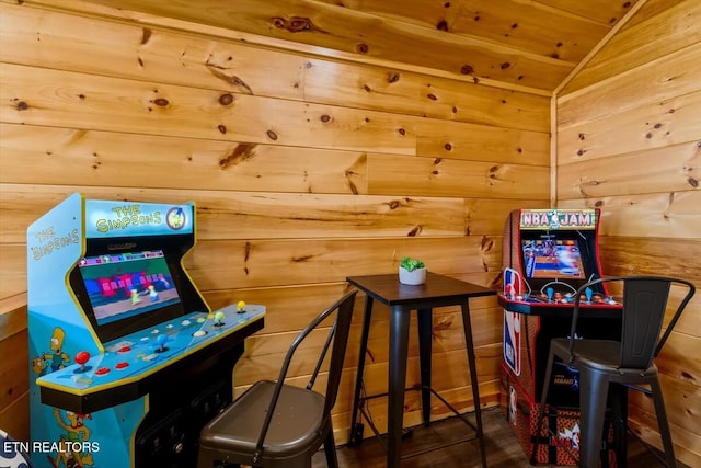 recreation room featuring wood walls and vaulted ceiling