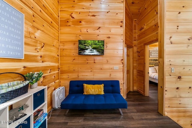 sitting room with dark wood-style floors and wood walls