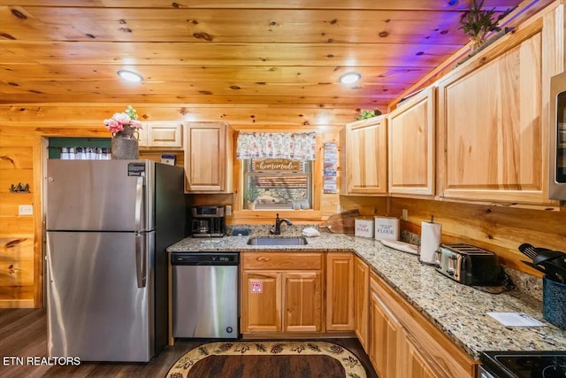 kitchen with light stone countertops, dark wood finished floors, a sink, appliances with stainless steel finishes, and wooden ceiling