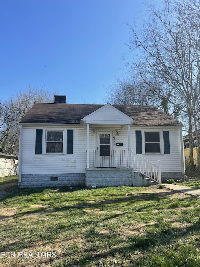 bungalow featuring crawl space, a chimney, a front lawn, and roof with shingles