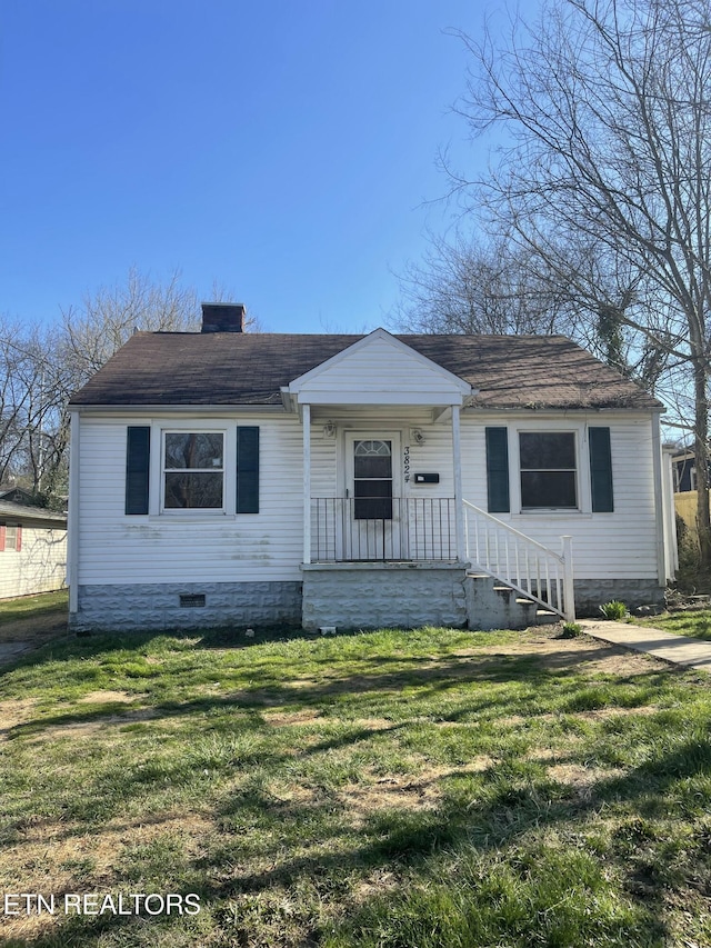 bungalow-style home with a front lawn, a chimney, roof with shingles, and crawl space