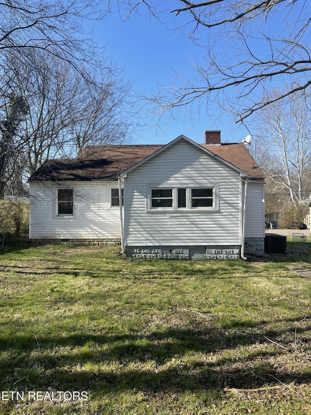 view of home's exterior featuring a yard, central air condition unit, and a chimney