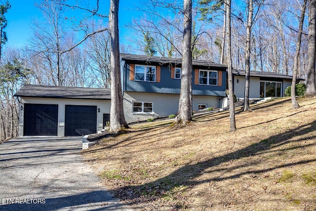 view of front of home featuring brick siding, driveway, and a garage